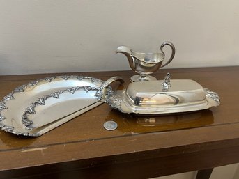 A Table Group Of Silver Plate Covered Butter Dish With Insert, Gravy Pitcher And Table Crumb