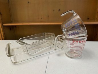 A Group Of 2 Pyrex Baking Dishes And 2 Measuring Cups