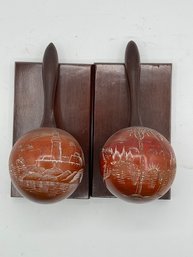 A Vintage Pair Of Maracas Bookends With Etched Scenes