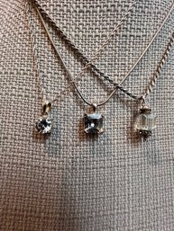 A Group Of Three Sterling Silver Pendents With Stones