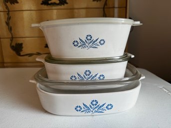 A Group Of Three Corning Casserole Dishes With Three Covers One Is Plastic