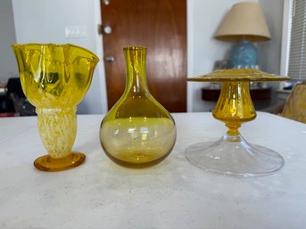 A Group Of 3 Hand Blown Amber Glass 2 Vases And A Candle Stick