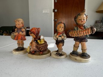A Group Of 4 Goebel Hummel Figurines Including Chick Girl, School Boy And Girl, And Accordion Boy