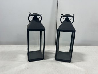 A Pair Of Large Black Metal Lanterns With Long Handles