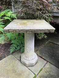 A Cement Pillar With Stone Top