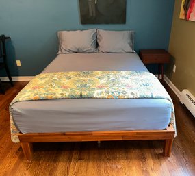 A Mid Century Modern Full Platform Bed With Mattress And Side Table