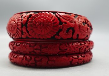 THREE VINTAGE CHINESE CINNABAR BANGLE BRACELETS