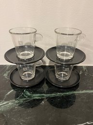 Set Of 4 Nespresso Glass Cups And Plastic Black Saucers