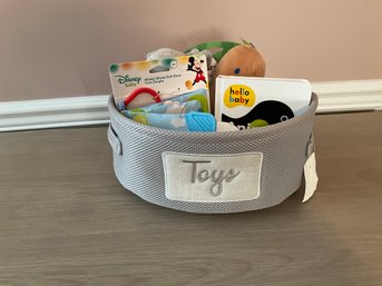 Cute  Gray Nursery Toy Basket Filled With New Toys And A Book