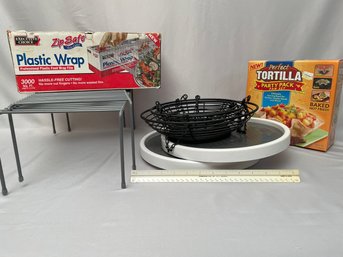 7 Pc Kitchen Lot: 2 Wilton Turntables, New In Box Tortilla Bowl Maker, Racks And Lg Plastic Wrap Roll