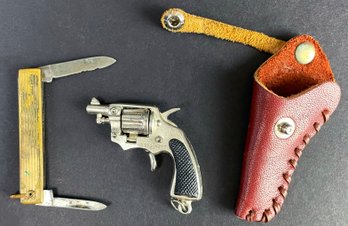 Pocket Knife And A Little Metal Gun In Holster