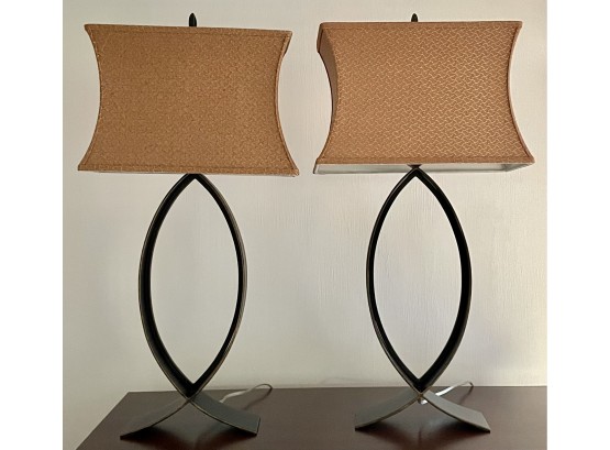 A Pair Of Metal Lamps With Gold Tone Fabric Shades