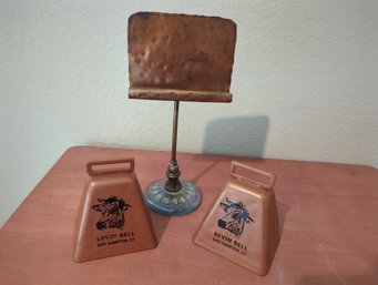 Two Copper Colored Cowbells And Standing Glass And Copper Business Card Display Stand  8 In Tall