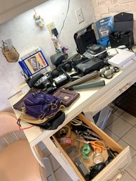 K/ Many Items - Drawer And Surface - Assorted Binoculars, Calculators, Cameras, Leather Clutches Etc