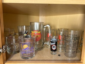 K/ Shelf Of 15 Various Promotional Glassware: Marshall Fields, Tun Tavern, Etched German Songs Etc