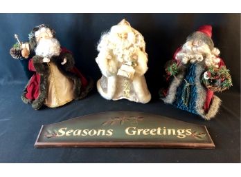 Seasons Greetings Sign And Three Santas