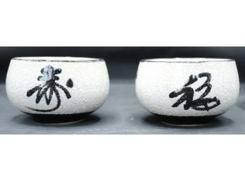 2 Chinese Tea Cups/dishes. Black Writing On White And Tan (012)
