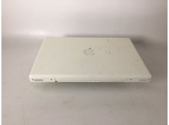 White Macbook Model A1181 Attached To An Arris Modem