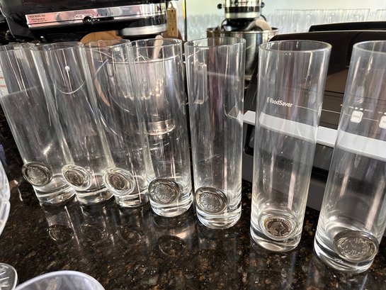 Lot Of Tall Clear Glasses. Some With Coins Affixed To Front