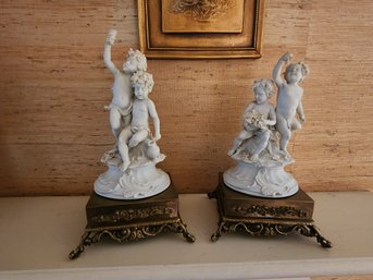 Pair Of Porcelain Cherub Figurines On Stands