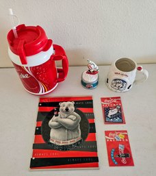 An Assortment Of Coca Cola Collectors Items Incl. Moving Music Box, Insulated Plastic Beverage Holder & More
