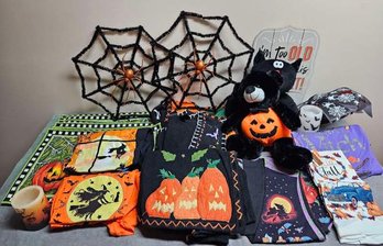 An Assortment Of Holloween Decor Incl Vests Aporns Tee Shirts  Candles And More
