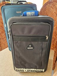 2 Suitcases Including A Black Samsonite With A Hard Back And A Green American Suitcase