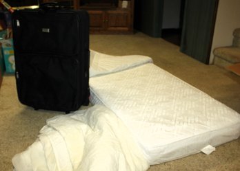 Crib Mattress With Protector And Large Harbor View Suitcase On Rollers