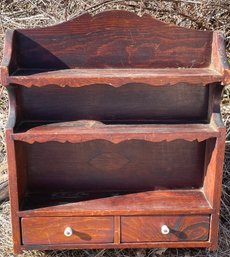 An Old Wooden Wall Shelf With Two Drawers