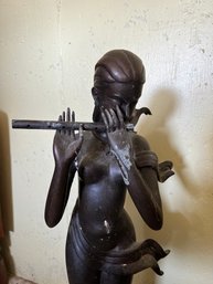 Tall Metal Statue Of Naked Woman Playing A Flute