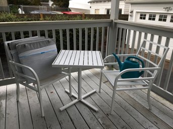 Table And Chairs With Cushions And Watering Can