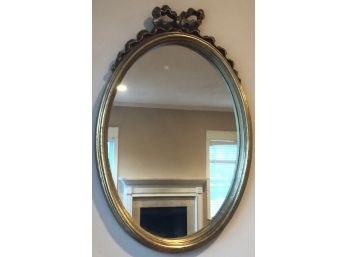 Brass Colored Oval Wall Mirror With Decorative Bow Top Piece