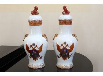 An Antique Pair Of Foo Dog Covered Tall Urns