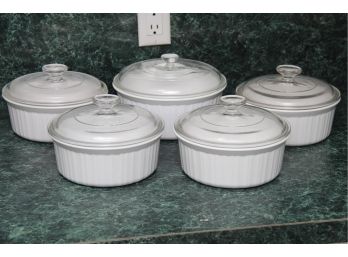 A Collection Of Round Pyrex Dishes With Lids