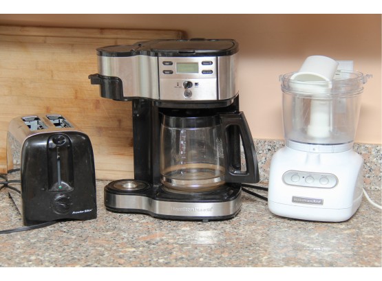 A Trio Of Kitchen Appliances Including Coffee Maker, Toaster And Food Processor