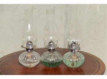 A Collection Of Three Glass Oil Hurricane Lantern