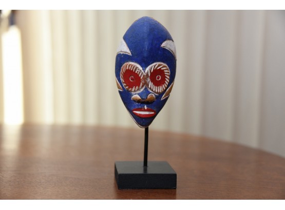 A Hand Painted Tribal Mask On A Stand