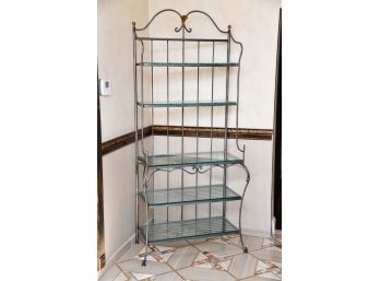 A Wrought Iron Bakers Rack With Glass Shelves