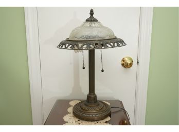 A Vintage Metal Lamp With Etched Glass Shade