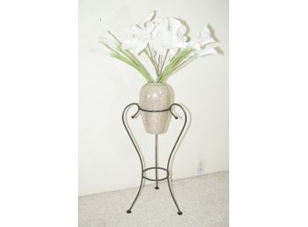A Three Legged Wrought Iron Plant Stand With Speckled Vase