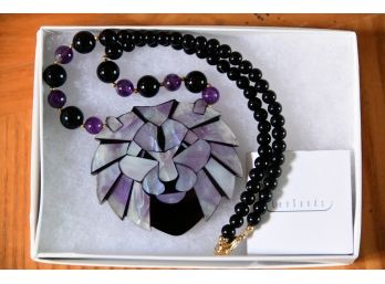 A Lion Pendant With Black And Purple Strand