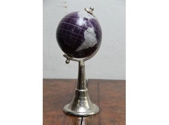A Tabletop Globe In A Silver Base