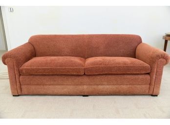 A  Rust Colored Sofa With Leather Piping