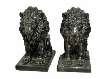 A Pair Of Black Molded Resin Lion Statues