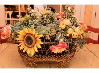 A Faux Floral Arrangement In Wire Basket Vase