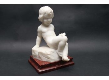White Child Statue On Red Marble Base