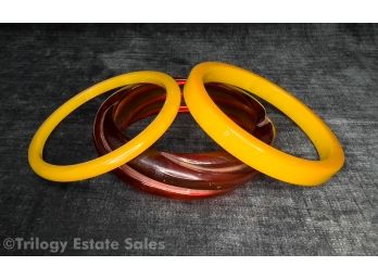 Two Mustard Yellow Bakelite Bangle Bracelets And Transluscent Amber Bangle