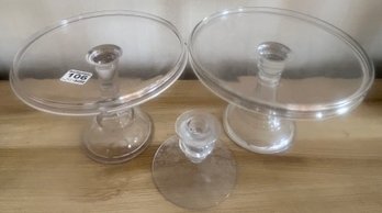 3 Pcs Vintage Pressed Glass 2 Footed Cake Plates, Largest 9.5' Diam. X 6'H And Single Etched Glass Candlestick